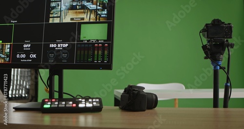Fotografie A modern live streaming studio setup featuring cameras, a switcher, and a monitor on a wooden desk