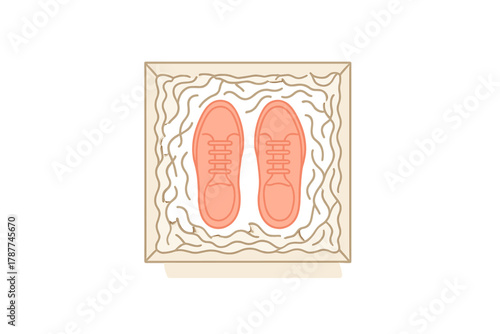 Overhead view of laced shoes resting on textured rectangular doormat