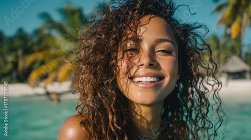 Radiant woman on a tropical beach: smile, curly hair, and sunshine
