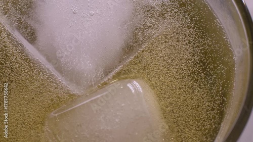 Cider with light foam served cold over ice. Bubbles sparkling in glass. Ideal for pairing with creamy soups or fresh garden salads, bringing balance and enhancing natural flavors