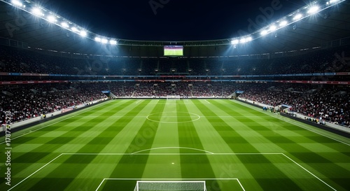 Wide Angle View of Soccer Stadium With Green Lawn and Goal Posts Full of Spectators Under Bright Lights at Night