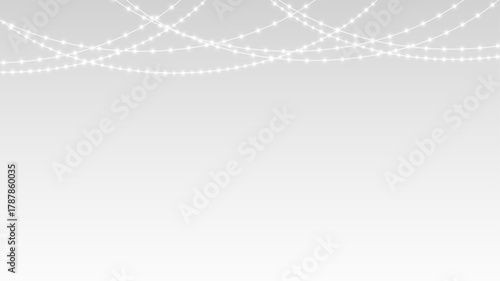 Garland glowing with festive Christmas lights and ribbons decorating holiday party banner stage.
