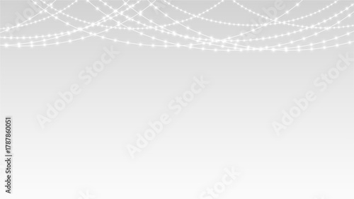 Garland festive Christmas holiday lights and ribbon decoration hanging over party banner stage.
