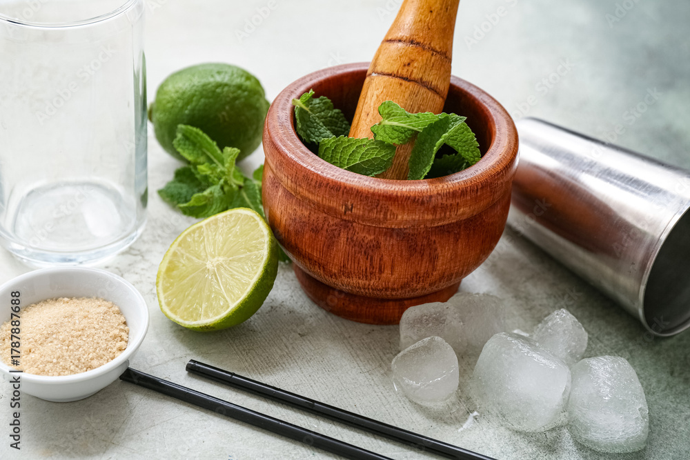 Naklejka premium Wooden mortar, pestle and ingredients for preparing mojito on grunge background, closeup