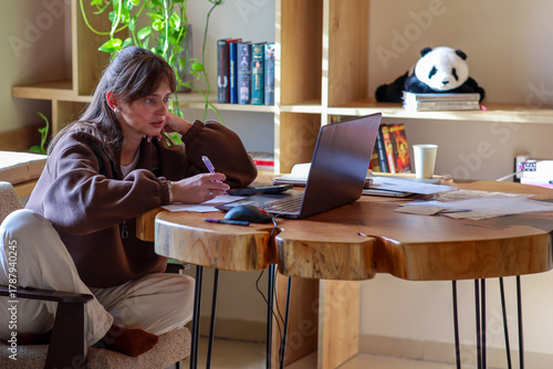 a young girl is working on a laptop, a homely cozy atmosphere