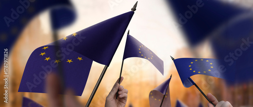 European Union flags in their hands on a blurred urban background
