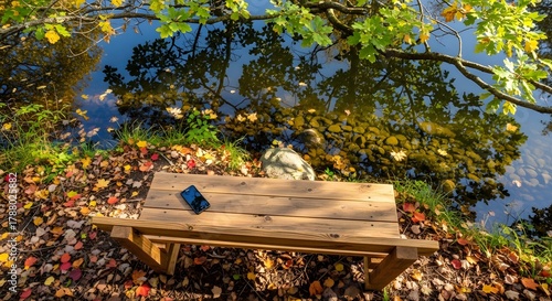 Wooden bench beside autumn tree reflecting in lake — Digital detox wilderness retreat for seasonal peace and mirror-like waters Stock royalty free