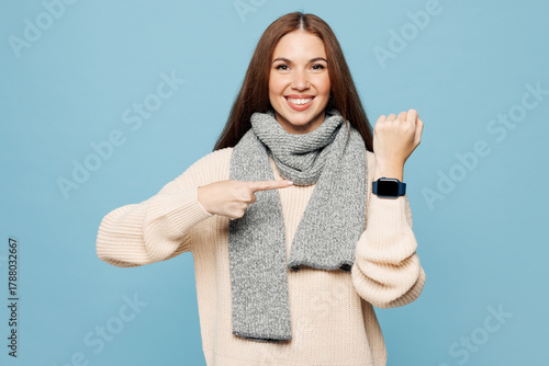 Young woman wear sweater scarf show use blank screen smartwatch to monitor health while fell unwell isolated on plain blue background. Healthy lifestyle ill sick disease treatment cold season concept.