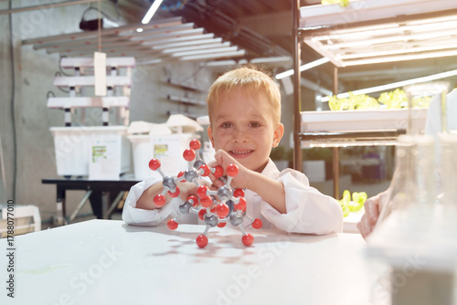Cute school boy playing with molecular toys in laboratory classroom.	

