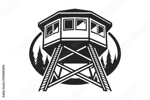 A black and white watchtower stands tall before the background of pine trees