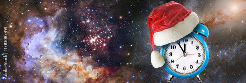 Clock wearing Santa hat spins in a galaxy filled with stars and vibrant colors during the festive holiday season