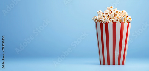 Striped popcorn box red white snack cinema movie night salted crunchy bucket minimal copy space popcorn kernel tasty crispy gourmet salty butter treat entertainment theater concession indulgent