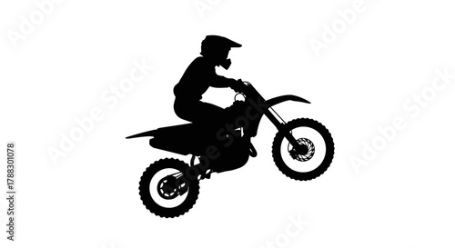 A silhouette of a person riding a motocross bike with the front wheel lifted off the ground