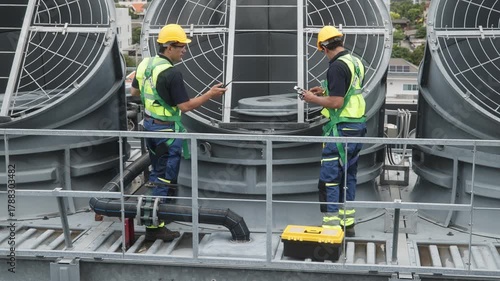 Engineers inspecting HVAC cooling systems on rooftop