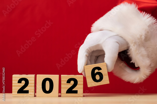 Wallpaper Mural Santa Hand Changing Wooden Blocks to 2026 Merry Christmas and Happy New Year Background Torontodigital.ca