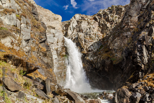 Waterfall Kurkure with rainbow in Altai Mountains territory, West Siberia, Russia.