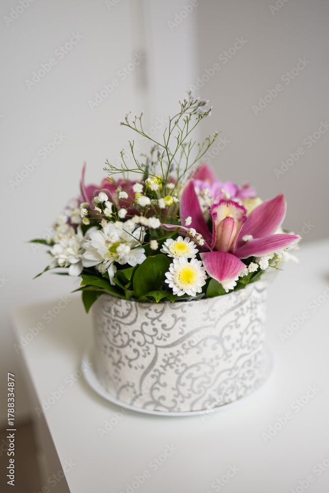 Fototapeta premium Elegant floral bouquet with pink lilies and daisies in patterned box. Warm emotions, freshness, and natural harmony.