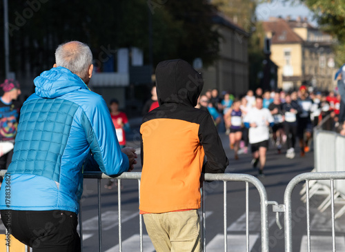 spectators watching diverse runners in a marathon race outdoors in ljubljana city street