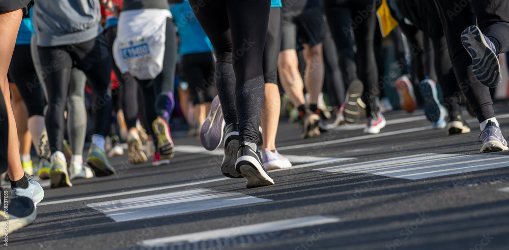 Fototapeta premium close up of marathon runners wearing athletic shoes running on city street in Ljubljana outdoor event
