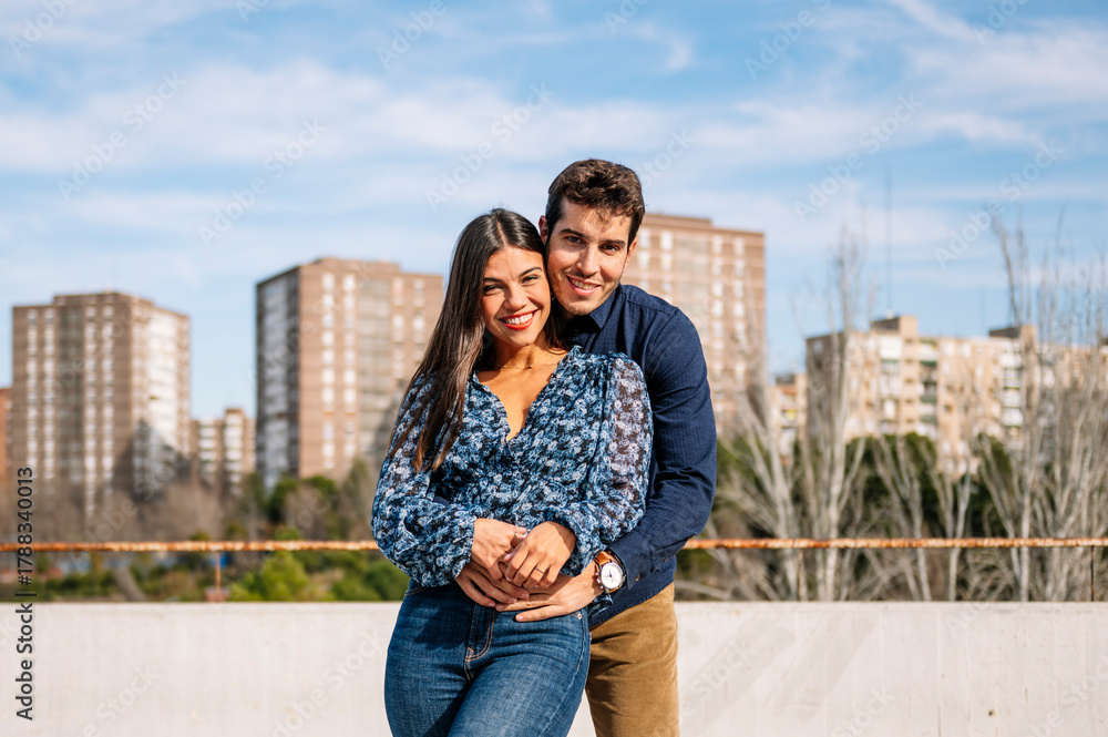 Fototapeta premium Happy young couple embracing outdoors, expressing love and connection in an urban setting