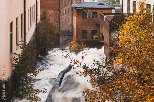 Water cascades at historic industrial site in Mölndal, Sweden during autumn