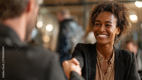 Woman smiling shaking hands with person indoors business collaboration concept