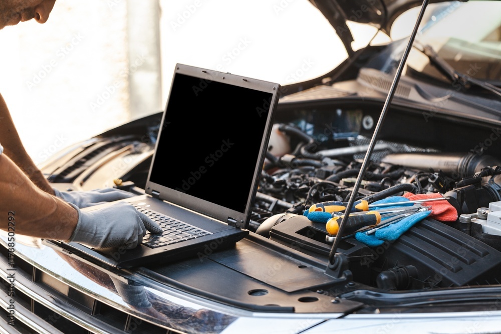 Fototapeta premium Mechanic uses a laptop to record error engine checks