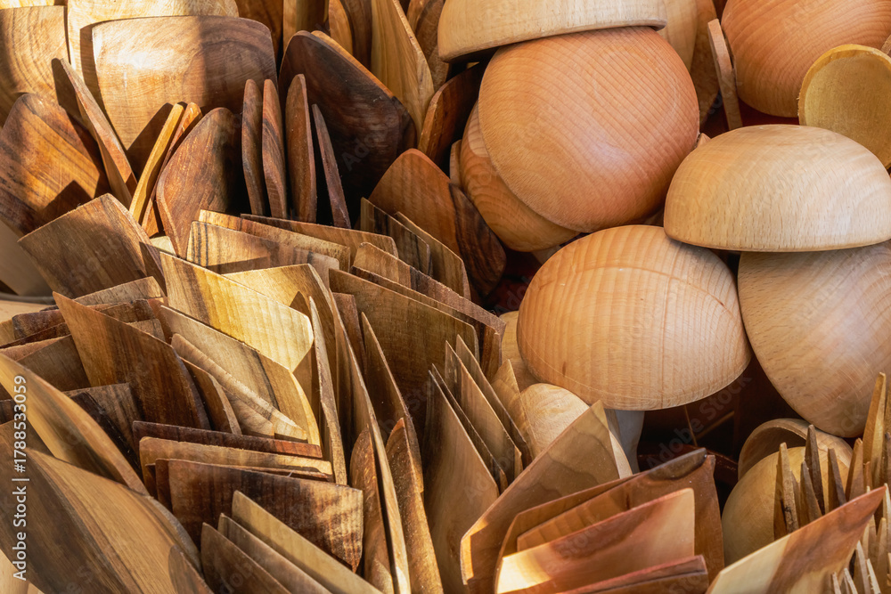 Fototapeta premium Handcrafted wooden kitchen utensils and bowls arranged in warm sunlight at a local artisan market display