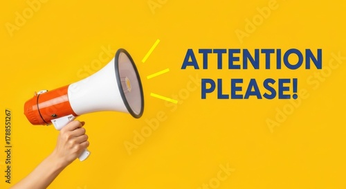 Hand holding a megaphone with attention please text on yellow background