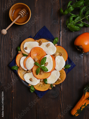 bright still life with persimmon and cheese salad on the table, flat lay