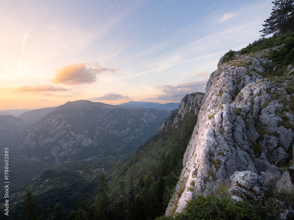Naklejka premium Mountain landscape with big white rocky cliff lit by setting sun, Montenegro