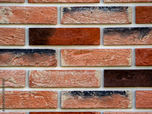 Abstract geometric background. Copy space. Decorative neat masonry made of multicolored bricks. Close-up.