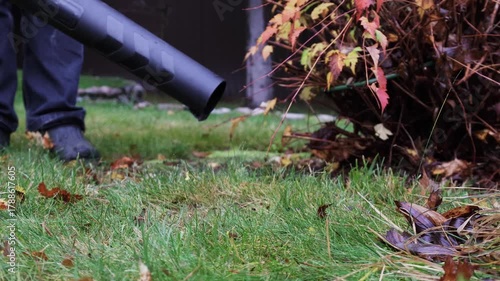 Close-up view of cordless leaf blower, removing leaves from grass, front view. High quality 4k footage