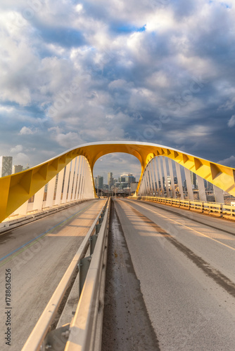 Yellow bridge with dramatic clouds at sunset - Cherry Street South Bridge with the Toronto skyline in the background