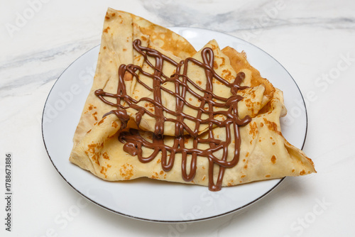 Crêpe au Nutella sur une assiette blanche, table en marbre, dessert français