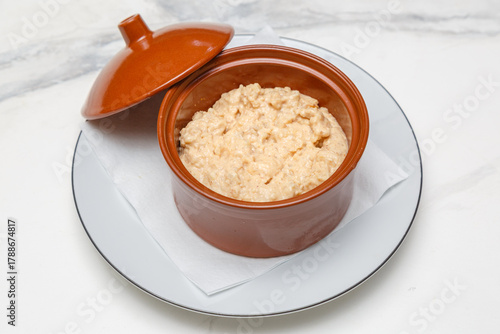 Teurgoule, spécialité normande à base de riz et de lait, cuit au four dans un pot en céramique sur une table en marbre