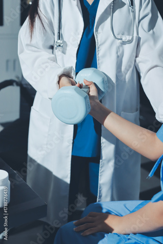 Physical therapist assisting a woman with dumbbell exercise