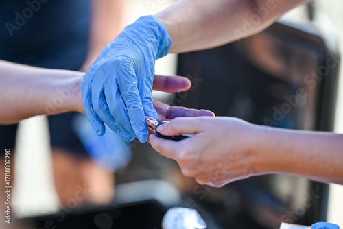 Tableau sur toile Nurse pricking a patient's finger to perform a blood glucose test