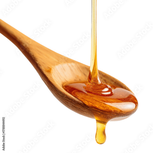 Golden honey dripping from a wooden spoon cut out