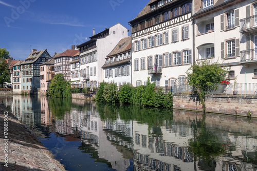 Strasbourg, France - August 26th 2025 : View of the Tanner's Quarter with half-timbered buildings and the Ill river and reflections on the water.