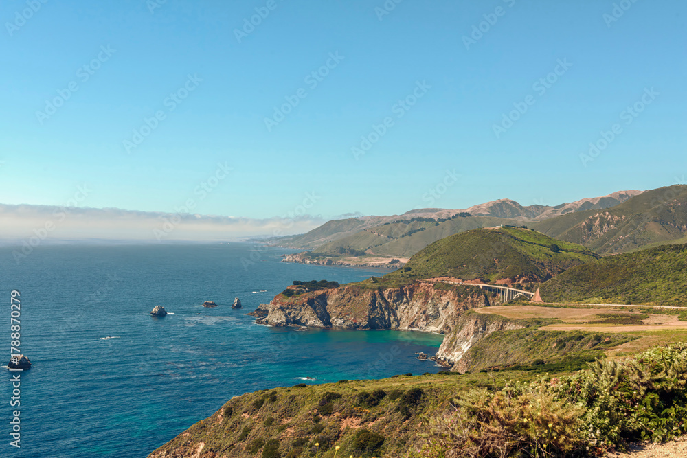 Fototapeta premium Coastal Bridge and Cliffs under bright blue Skies