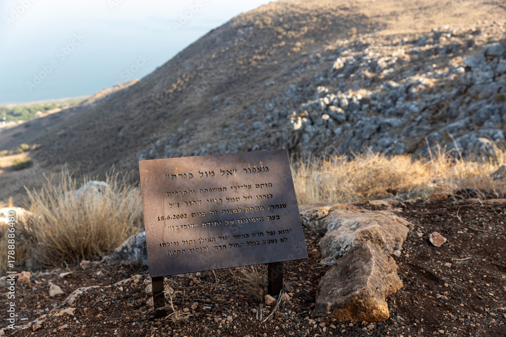 Φωτογραφία Tiberias, Israel - January 11 2025: A metal memorial sign with hebrew inscription ( mount arbel) set against the blurred background of the dry hill and sea