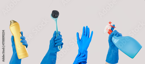 Hands with blue rubber glove holding cleaning supplies isolated on grey background. 