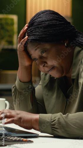 Vertical Video African american drained woman experiencing weariness after hours at desk, falling asleep with head in her palm. Overwhelmed anxious and fatigued worker deals with burnout and mental