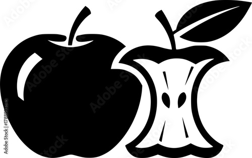 A whole apple sits near a bitten apple core with a leaf
