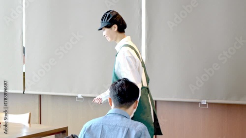 カフェスタッフが車椅子のお客様を案内しているシーン