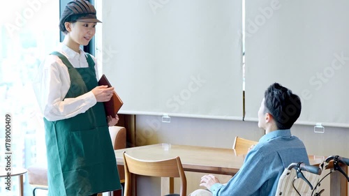 カフェスタッフが車椅子のお客様を案内しているシーン