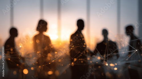 Silhouettes of business people against bright sunset with digital network overlay