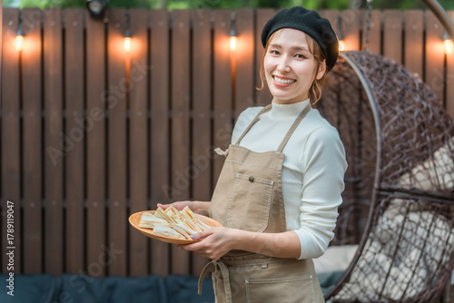 A young Asian woman wearing an apron working in a stylish cafe
