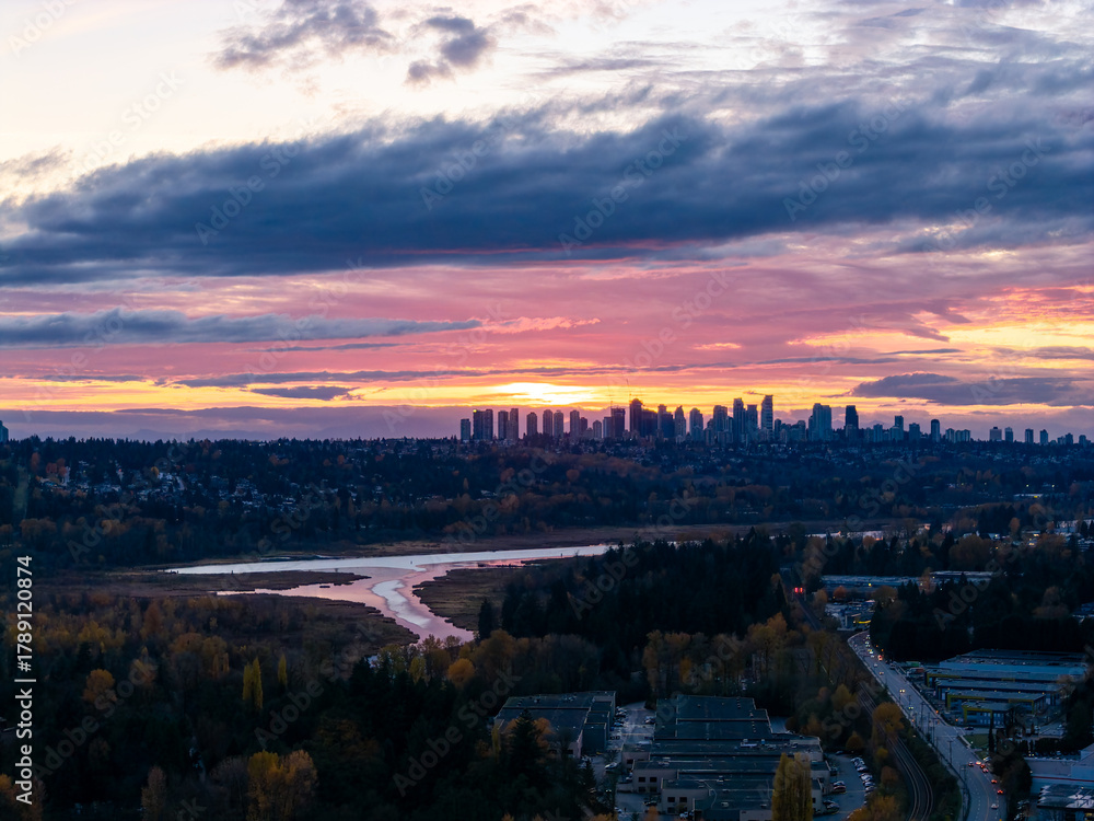 Fototapeta premium Sunset Over Burnaby Skyline at Dusk with River and Forest in Greater Vancouver